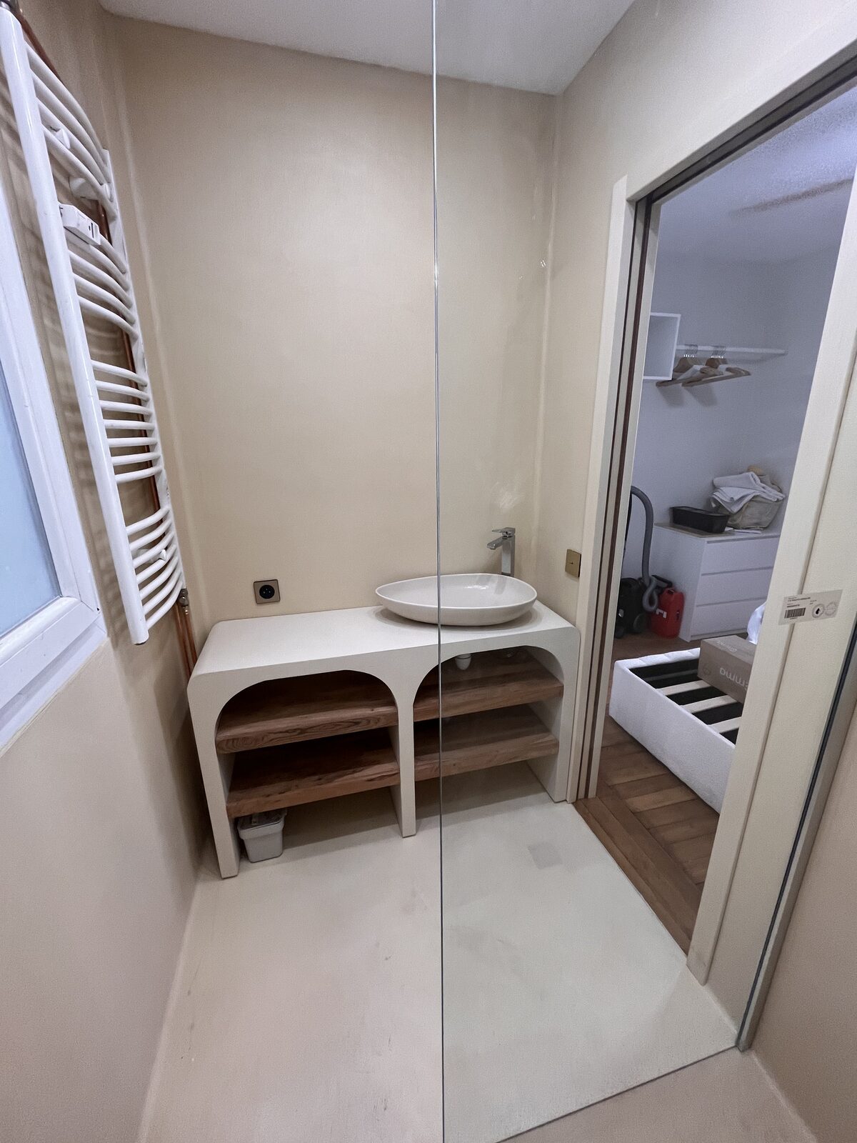Salle d'eau avec douche à l'italienne, paroi vitrée, plan vasque sur mesure et sèche-serviettes