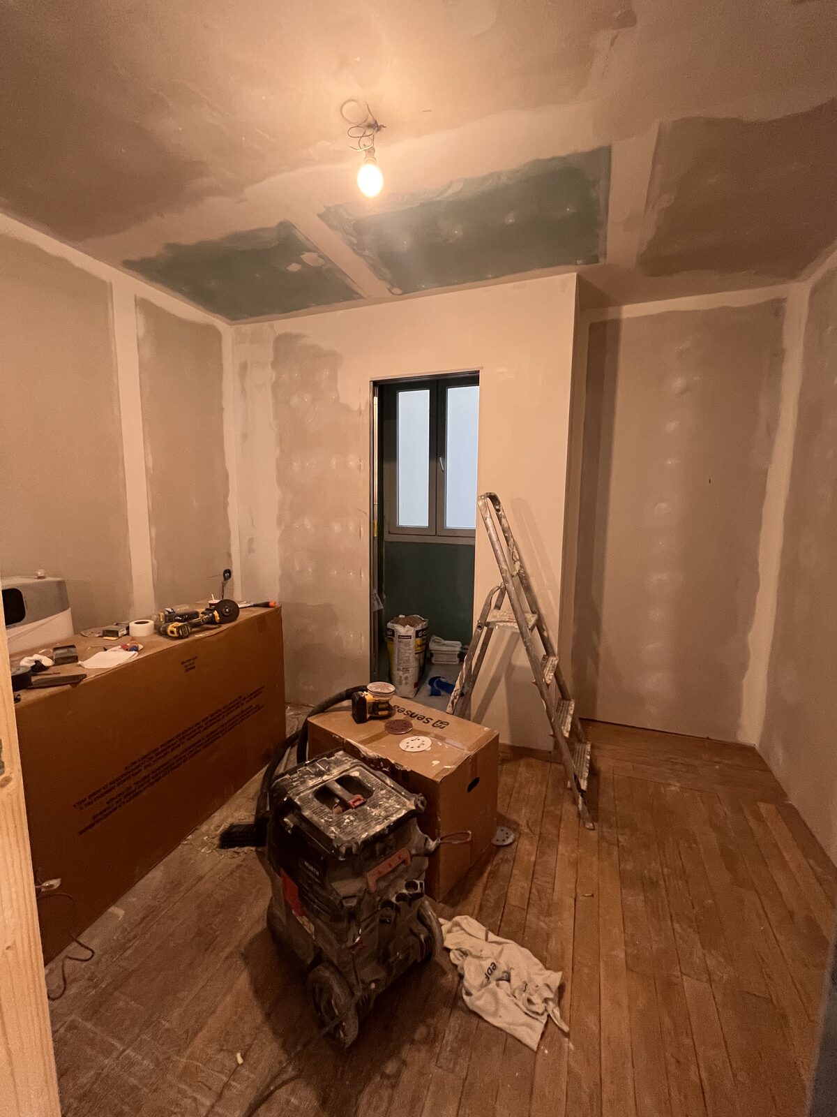 Pièce en travaux avec doublage en plaques de plâtre, bandes et enduit avant peinture
